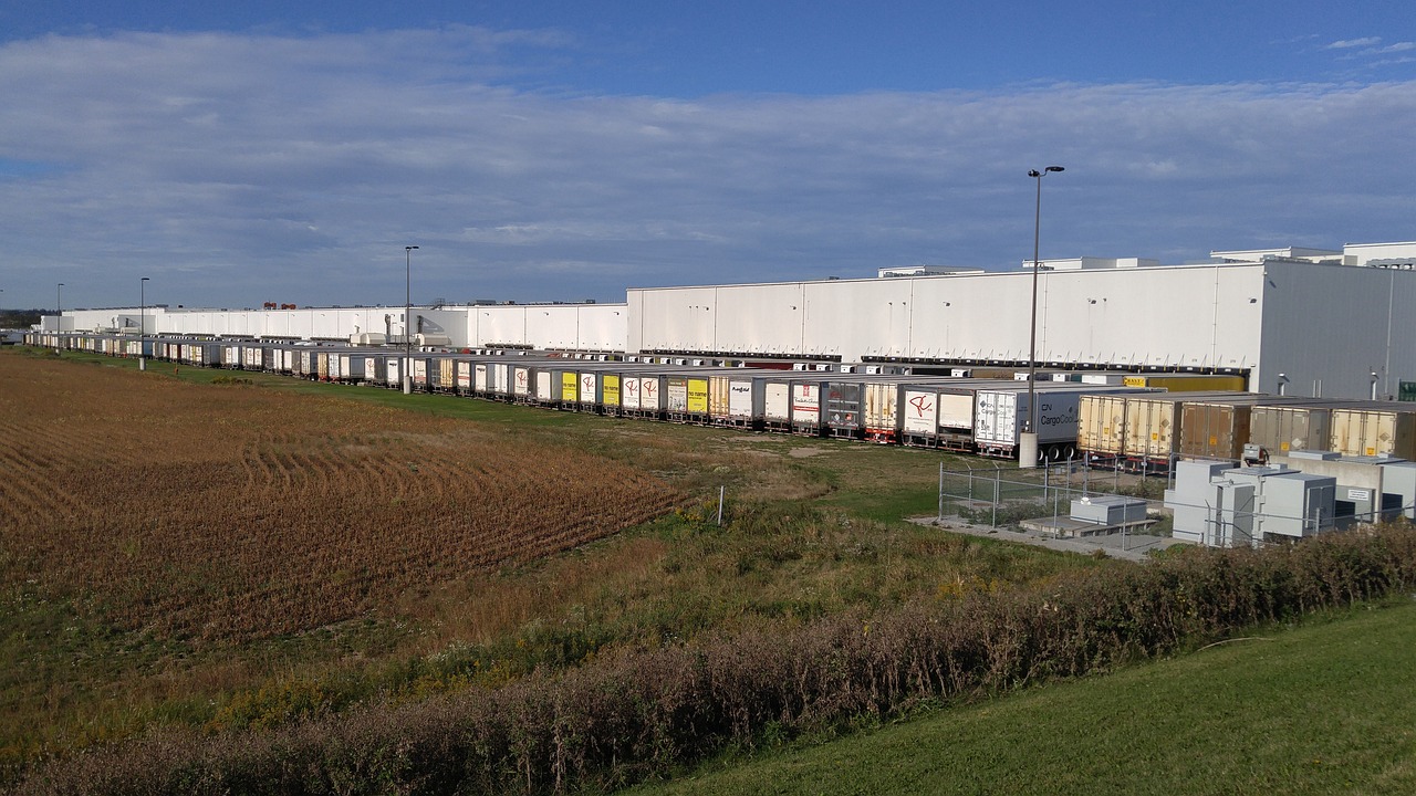 Long shot of line of depot trucks at food warehouse facility.