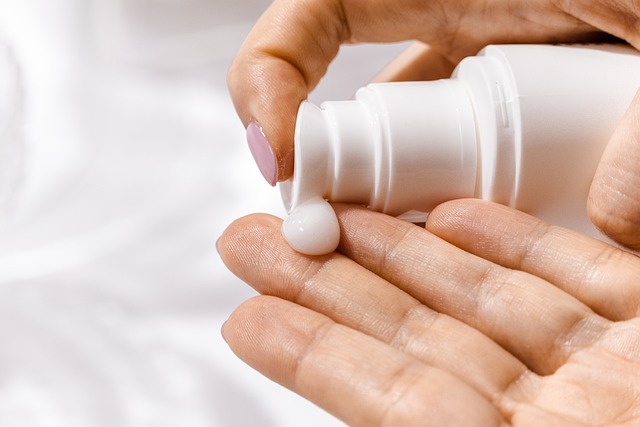 Close up of person's hands applying lotion on white background for Registrar Corp serious adverse events for cosmetics guide.