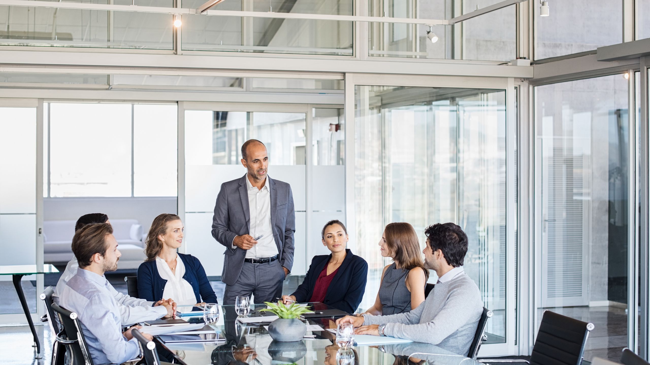 A PCQI leads a food safety culture meeting in a white office space.