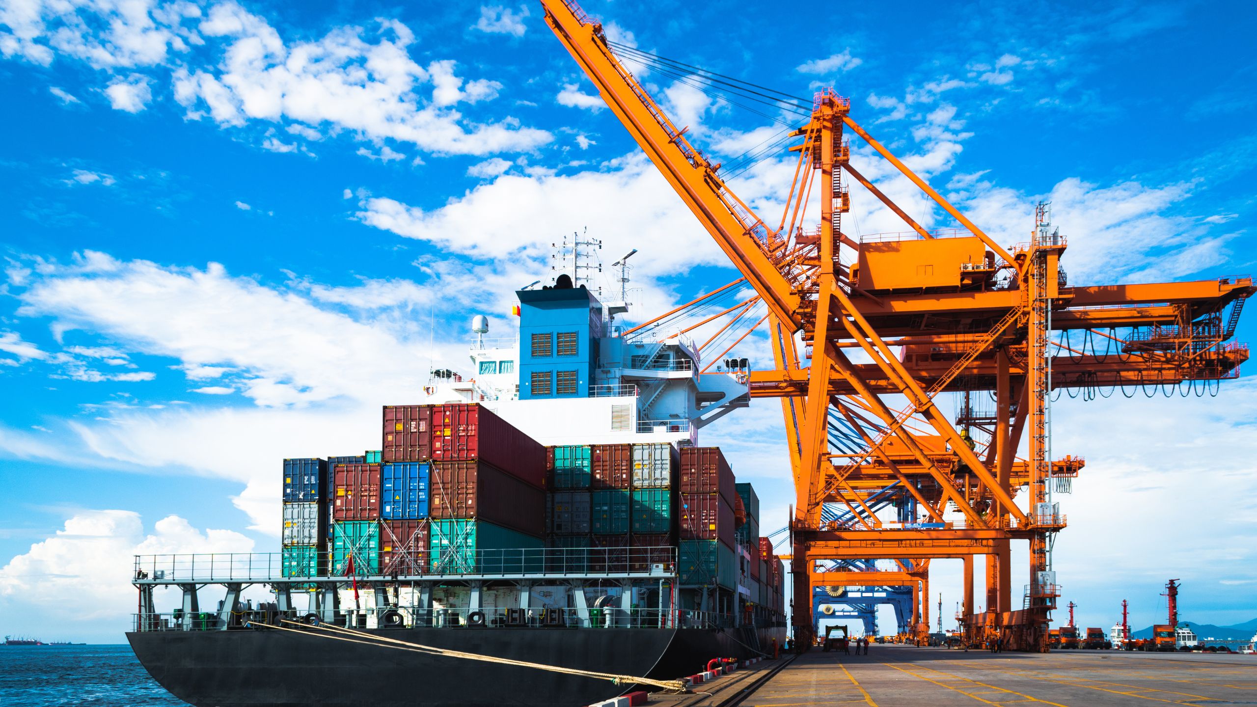 A trade ship rests at port as a crane unloads product that is both SQF & FSVP compliant.