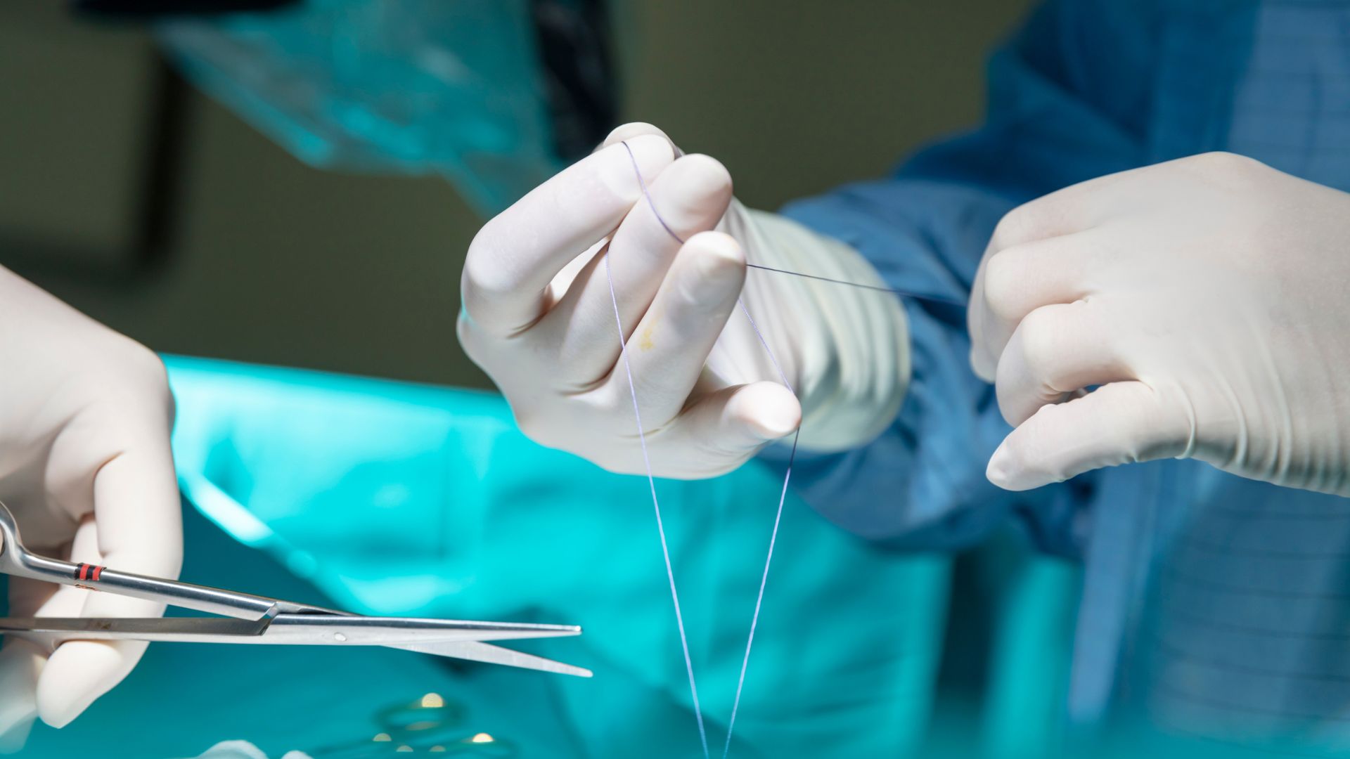 A surgeon uses biodegradable sutures to close up an incision.