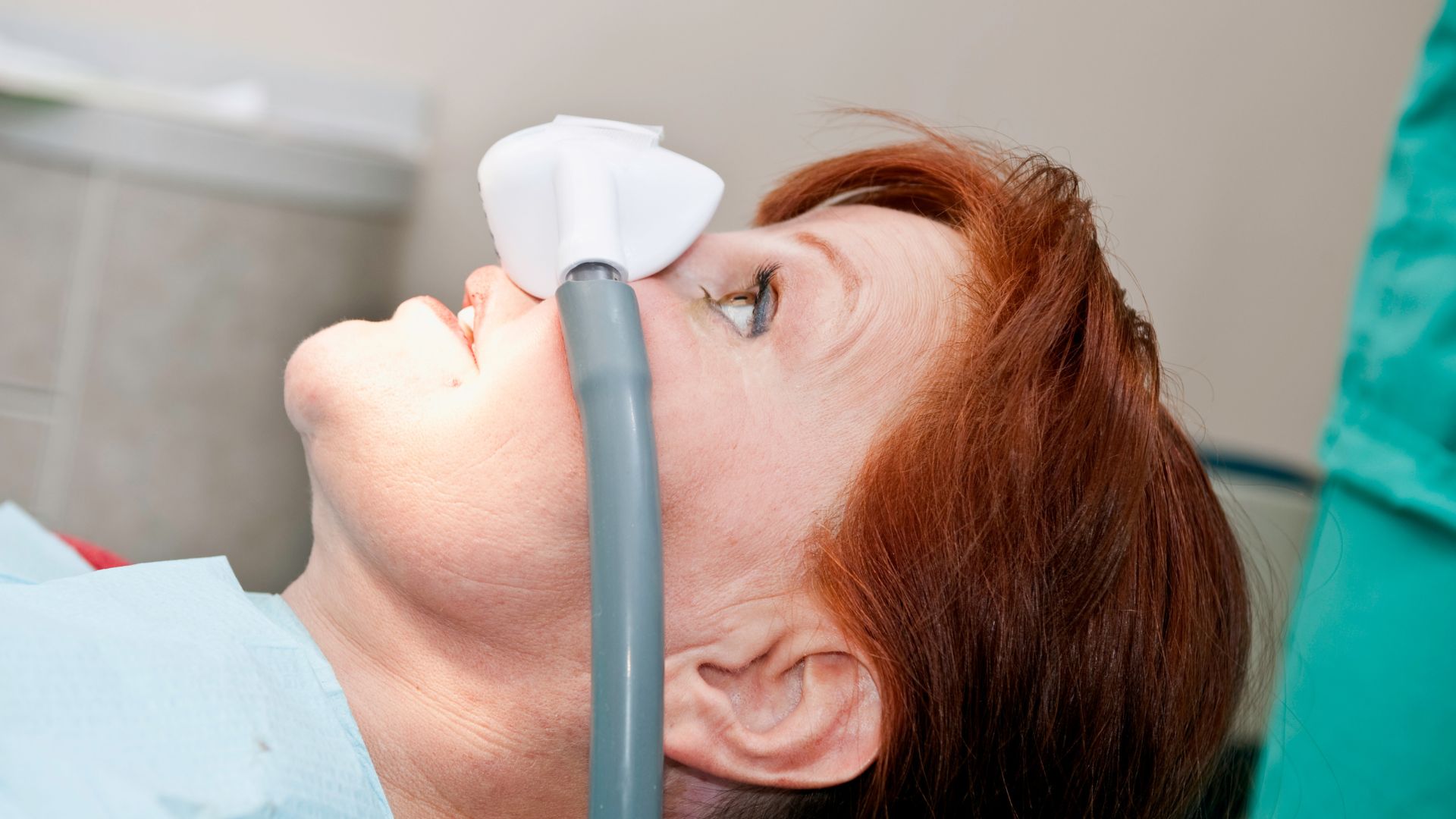 A woman rests while connected to Dental Anesthesia Devices.