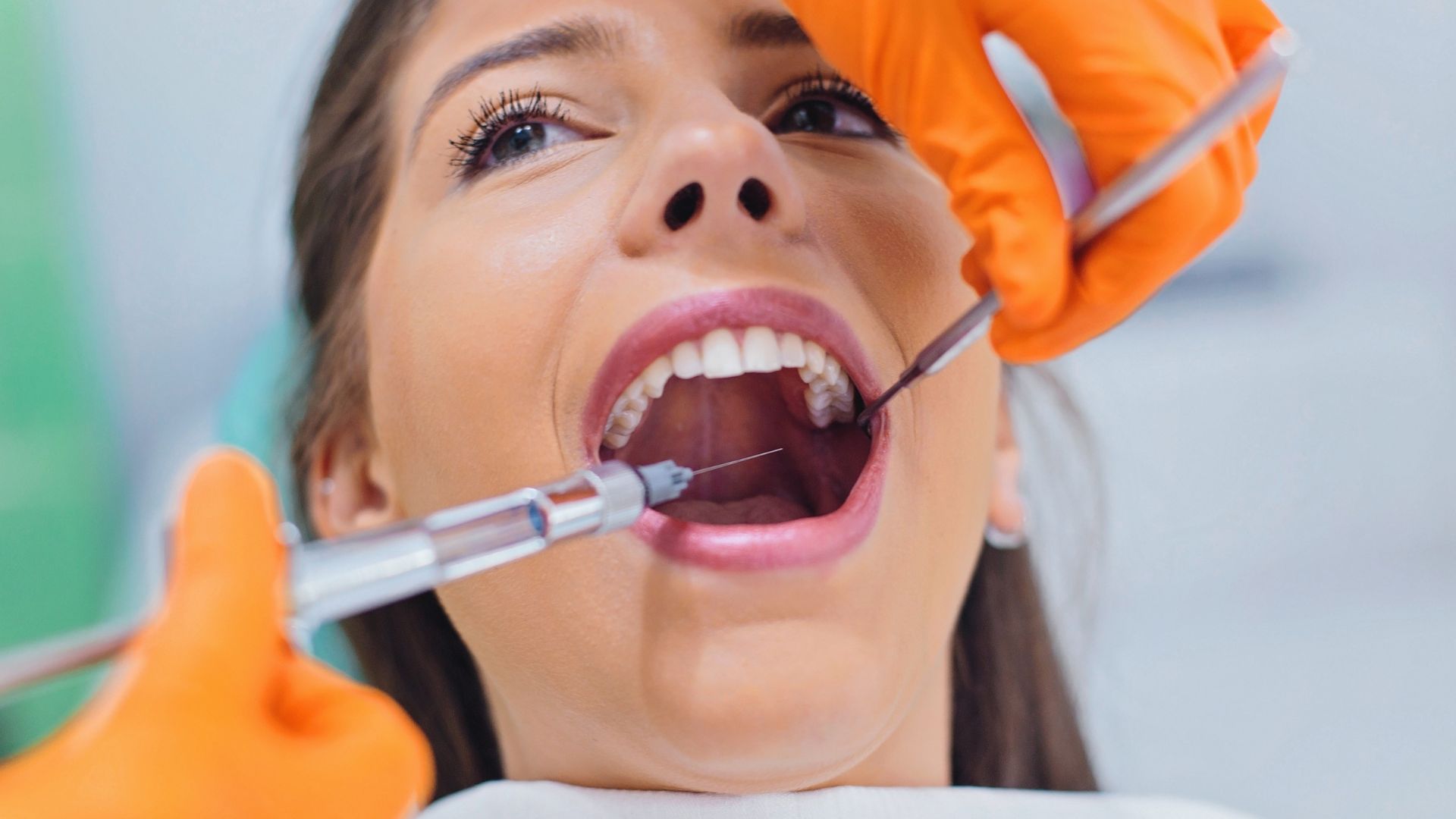 A woman recieves dental biologics via syringe to help numb before her procedure.