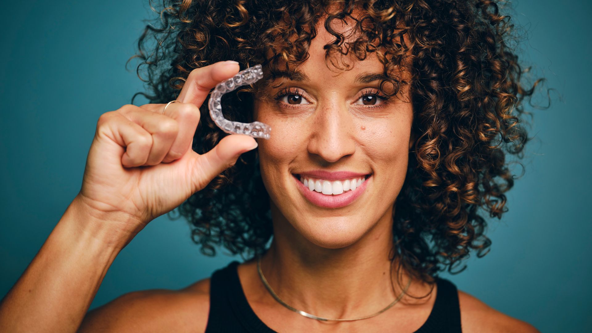 A woman holds up one of many dental wearables on the market.