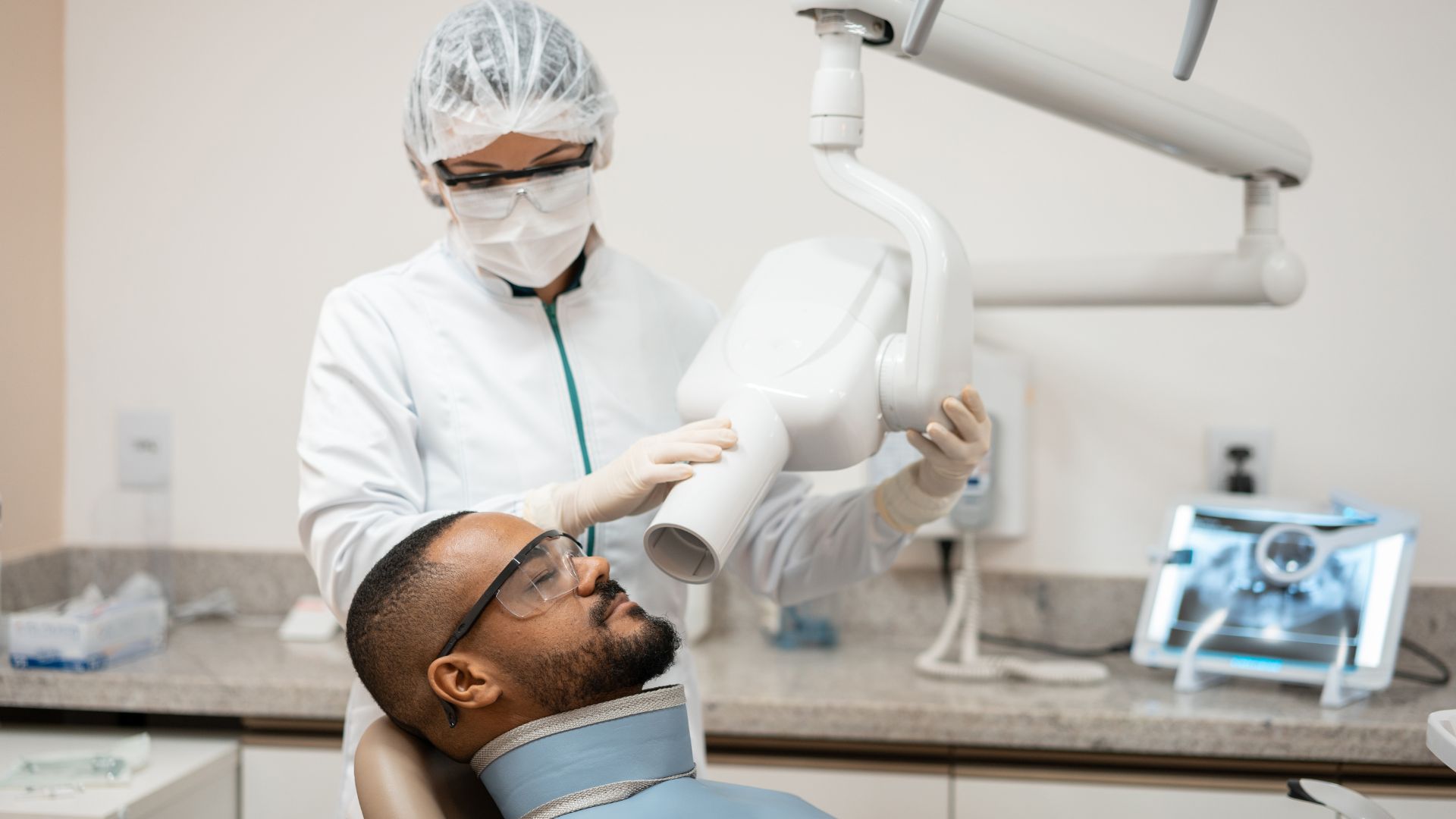 A patient reclines, about to receive a dental x-ray.