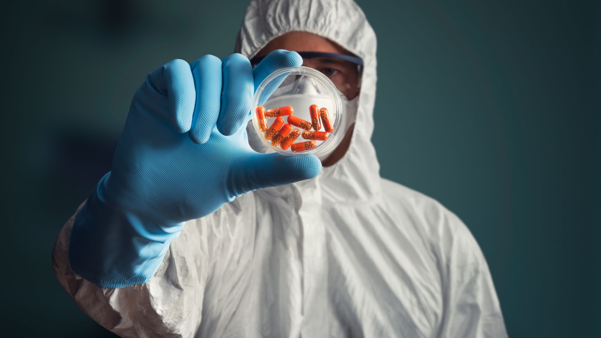 A Lab tech holds up a sample of pharmaceuticals that fall under FDA drug establishment registration.