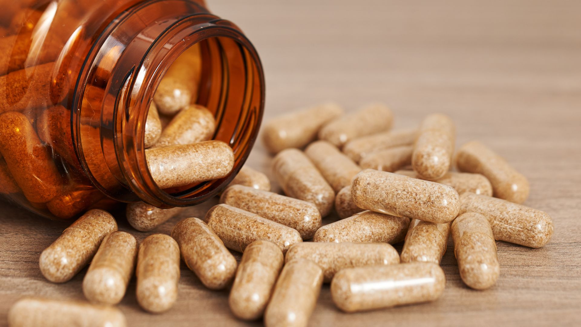 A bottle of drugs with capsules spread across a table. An example of a product subject to global master file regulations.
