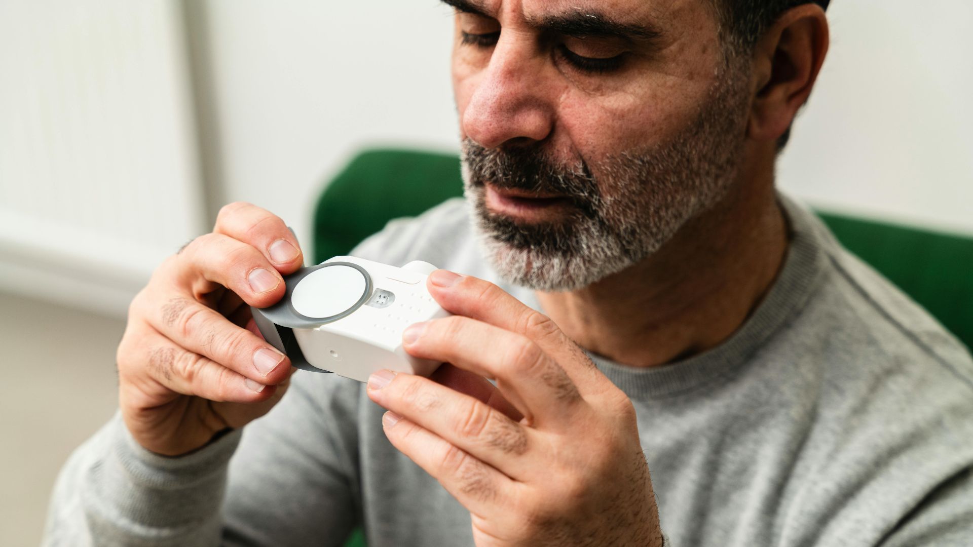 A man looks awkwardly at a medical device fearing an adverse event, the basis behind many eMDR submissions.
