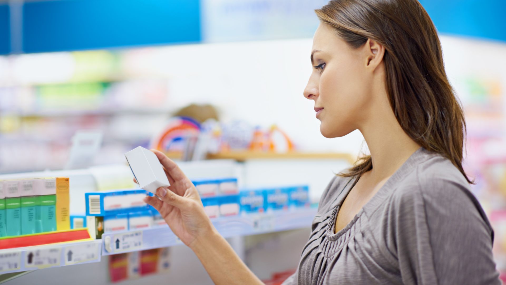 A woman studies an OTC drug unaware of the OMUFA fees that went into making it available.