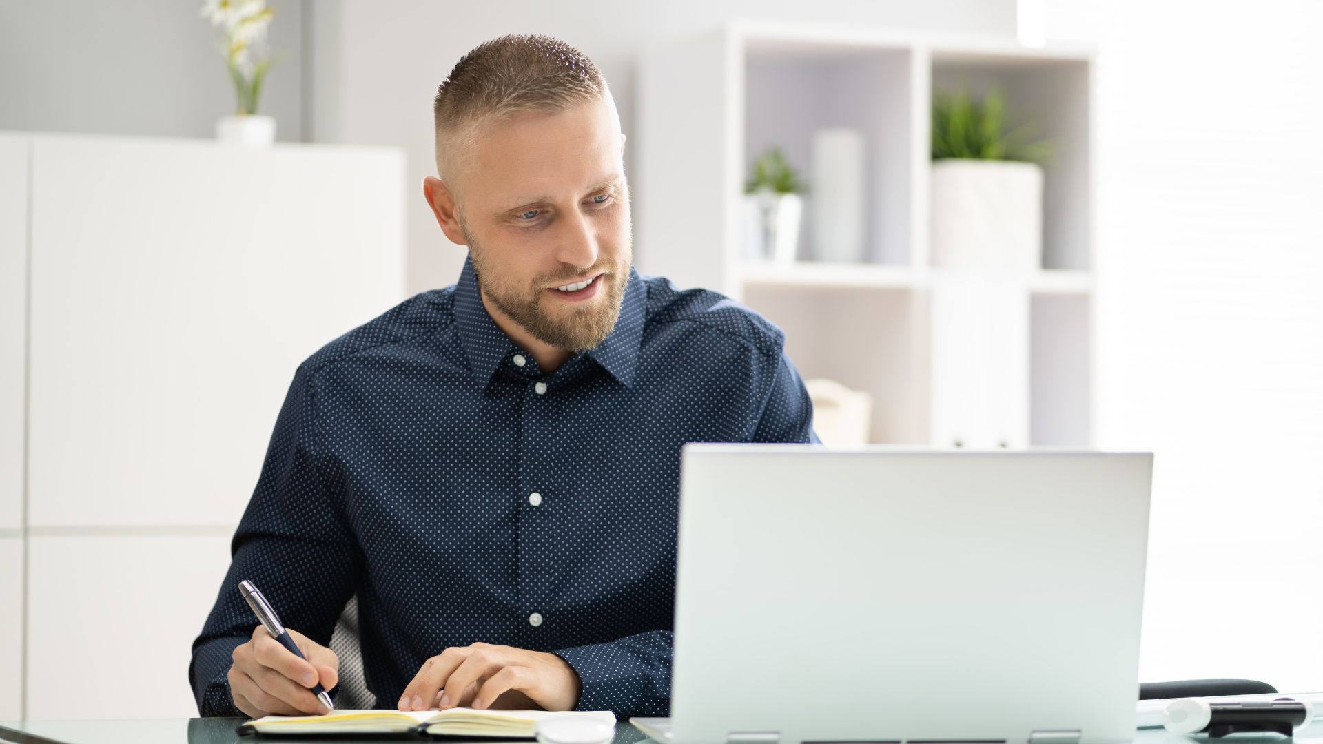 A man sits at his laptop undertaking Registrar Corps PCQI Training.
