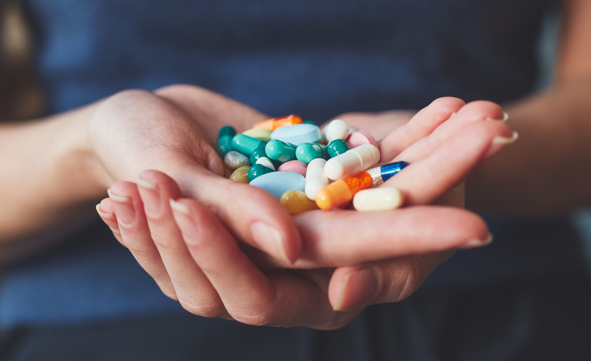 A woman holds various products from drug manufacturers.
