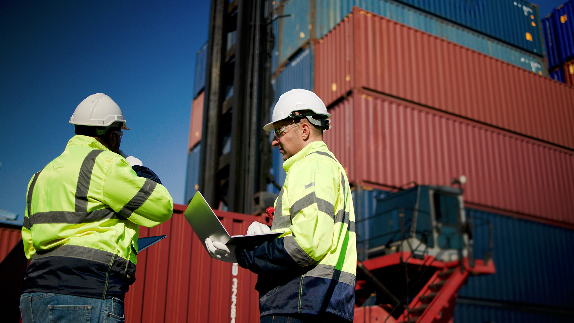 workers inspecting shipping containers at port