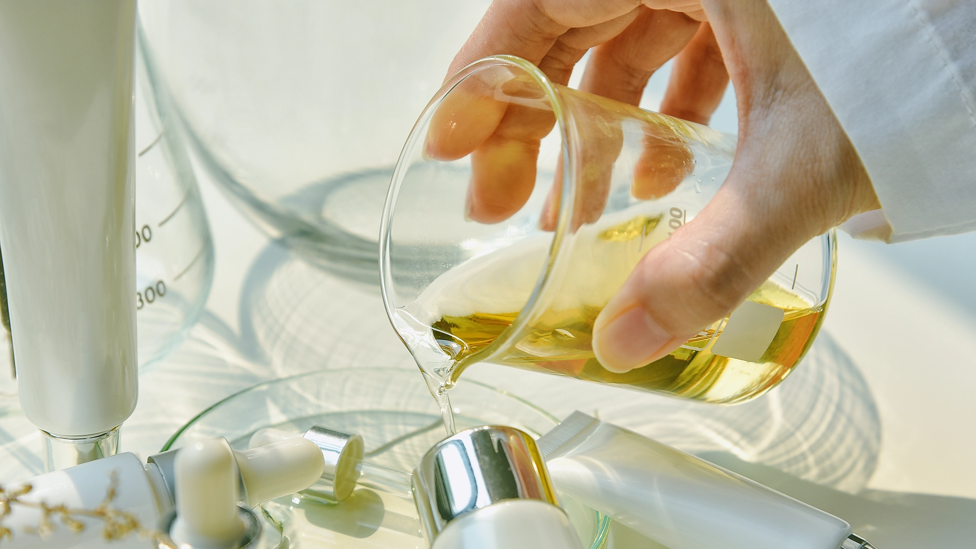 cosmetic product formulation showing liquid in beaker being poured